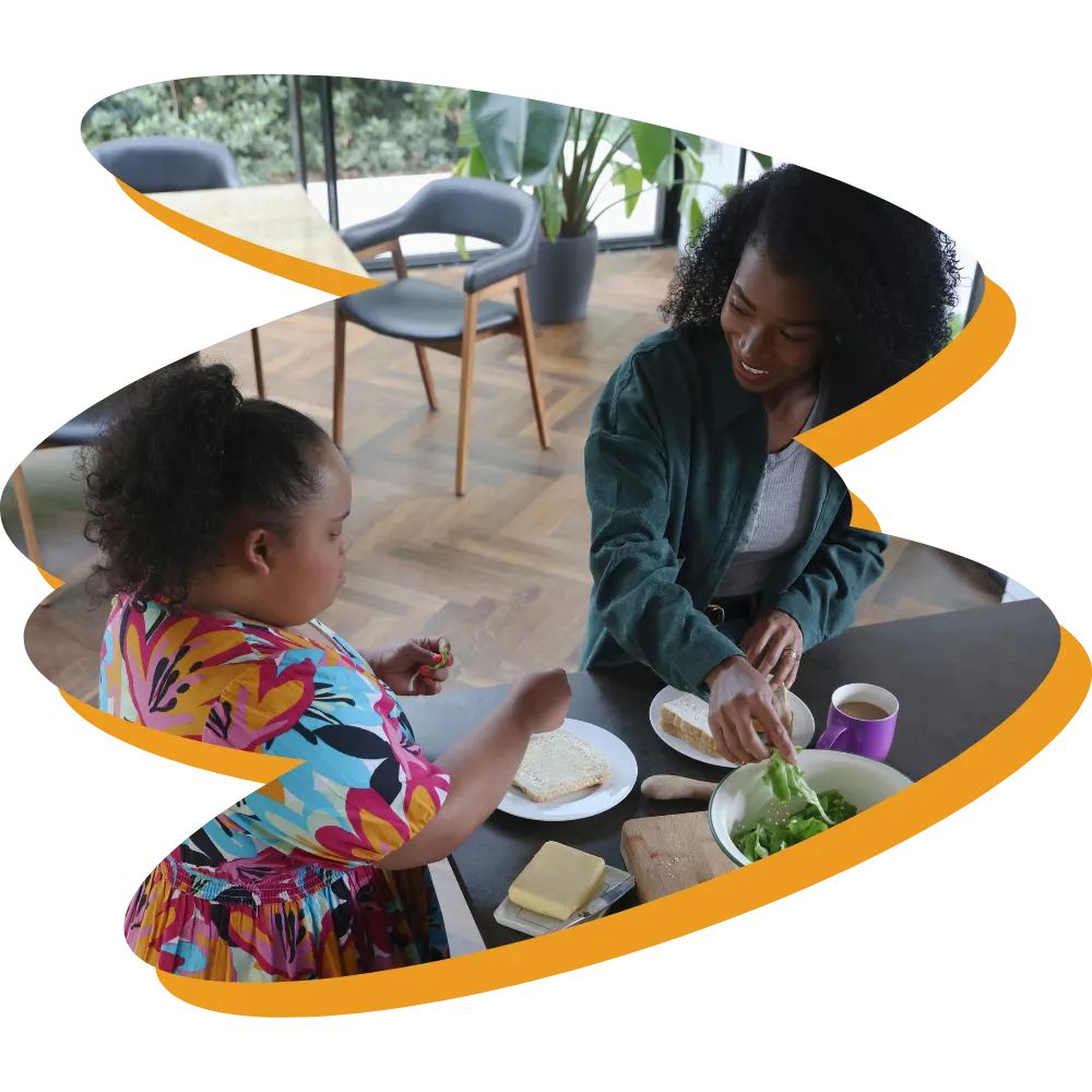 Disabled woman at kitchen counter with support worker