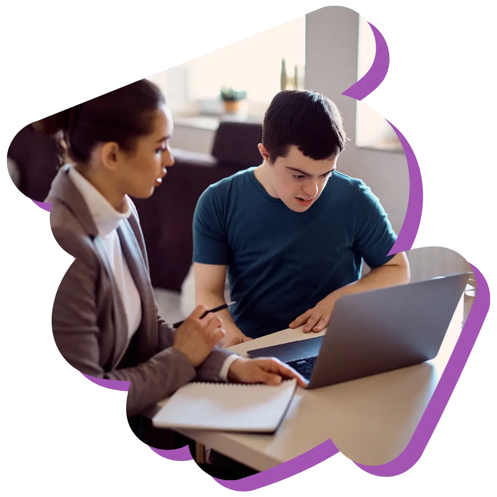 Disabled man and support worker looking at laptop together