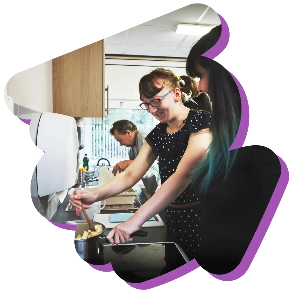 Disabled girl cooking with support worker